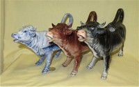 Three German realistic porcelain cow creamers from similar nolds with different coloration
